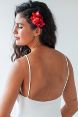 La espalda de una novia está en primer plano, luciendo un top de novia con delicados tirantes