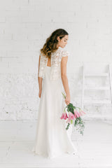 Novia luciendo un vestido de espalda descubierta. Combina un vestido lencero con un crop top boho en tul bordado