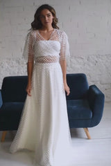 video de modelo andando a cámara y moviendo su vestido de novia dos piezas contop bolero de volantes de tuk.