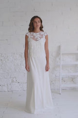 Modelo andando a cámara con vestido de novia dos piezas con crop top de flores bordadas blanco con espalda abierta.