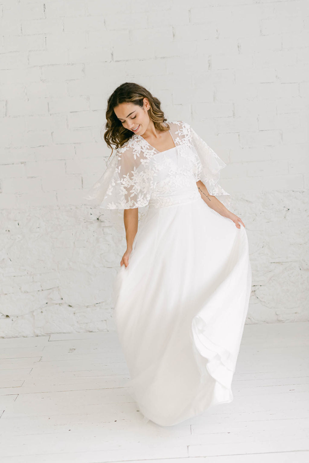 Novia mostrandp el vuelo de su vestido de tul. La capa que lleva en la parte superior también tiene mucho movimiento