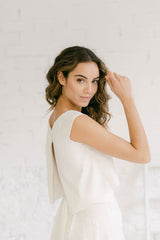 Modelo vestida como novia con un crop top de mangas cortas y espalda abierta