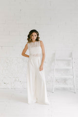 Novia de pie con pantalón palazzo, tube top y crop top de pequeñas flores blancas