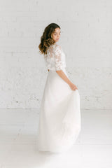 Modelo agarrando su falda de tul. Complementa su maravilloso vestido de boda civil con un crop top de novia con manga