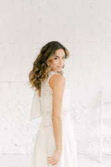 Modelo vestida como novia. Viste un crop top de tul de flores que es pura magia junto con un pantalón