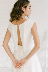 Detalle del crop top de novia. Se pueden ver las mangas sobre el hombro, el botón en la parte superior y la apertura. Perfecto para mostrar tatuajes o sentirte más sensual y atrevida sin renunciar a la elegancia