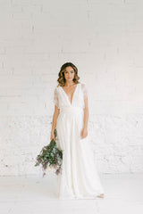 Modelo de pie luciendo un precioso mono de encaje blanco. Los pantalones son estilo palazzo.