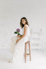 Modelo vestida como novia luciendo un elegante pantalón de novia palazzo. En la parte superior lleva un crop top. El estilo es minimalista.
