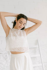 Novia fotografiada de cerca. Se puede ver con detalle su dos piezas con pantalón y top tul de flores. Las flores son pequeñas y blancas, con el centro dorado