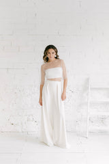 Novia de pie con palazzo, tube top y bolero de flores