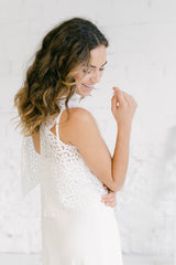 Novia fotografiada por detrás con un vestido lencero y un crop top sin mangas. Lleva un estilo hippie chic.