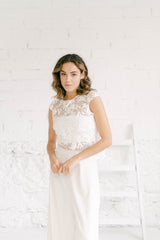 Novia mirando a cámara. Todo es blanco y minimalista, como su vestido dos piezas novia