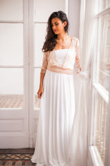 Modelo luciendo su falda de novia sencilla al lado de una ventana