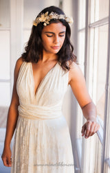 Modelo con su brazo recostado sobre un ventanal, luciendo el vestido de novia con encaje