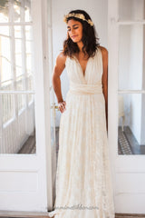 Novia en un vestido de encaje champagne, de frente con una corona de flores doradas, mano delicadamente posada en la cintura