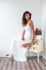 Imagen de una novia sentada, vistiendo el clásico vestido de novia blanco Marie y sosteniendo un encantador ramo de flores