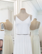 Un top de novia sencillo con tirantes descansa en un busto en el atelier.