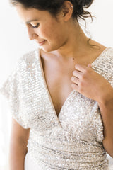 Modelo mirando su top de lentejuelas, parte superior de su vestido de novia