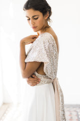 Modelo luciendo su top de lentejuelas, se ve levemente el detalle en la espalda