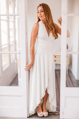 Modelo luce vestido de novia asimetrico mirando levemente hacia su derecha