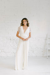 Modelo mirando a cámara con manos a la altura de la cintura. La chica lleva un vestido de novia pantalon con top con encaje.