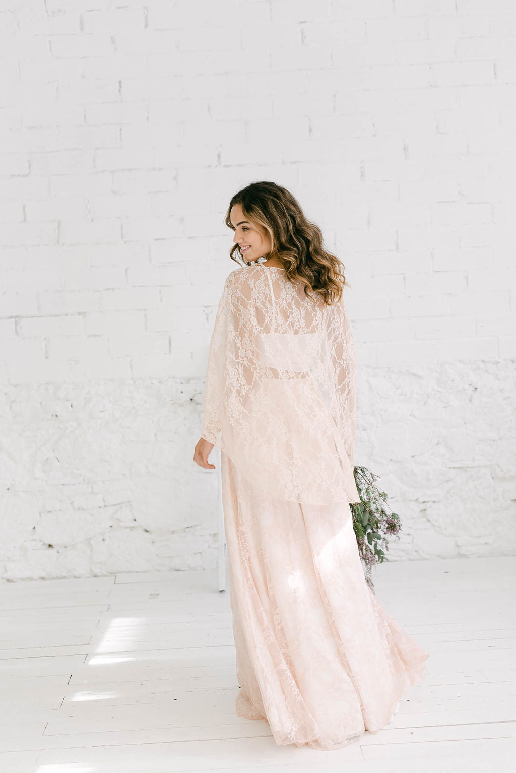Modelo chica de espaldas a la camara con vestido de novia dos piezas en color rosa cuarzo.