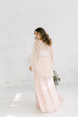 Modelo chica de espaldas a la camara con vestido de novia dos piezas en color rosa cuarzo.