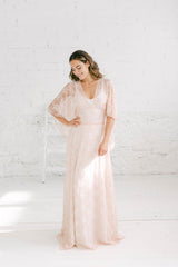 Modelo chica con vestido de novia dos piezas de encaje en color rosa cuarzo.