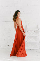 Modelo de espaldas mirando hacia atrás a la cámara. El vestido tiene escote en V y espalda cruzada en X.