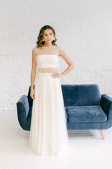 Modelo con vestido de novia dos piezas formado por falda y top de mangas cortas en tela de tul de florecitas blancas.