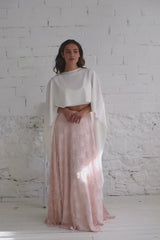 video de chica modelo andando a camara con capa maxi blanca y falda de encaje en tela de color rosa cuarzo. La capa refleja su maravilloso vuelo.