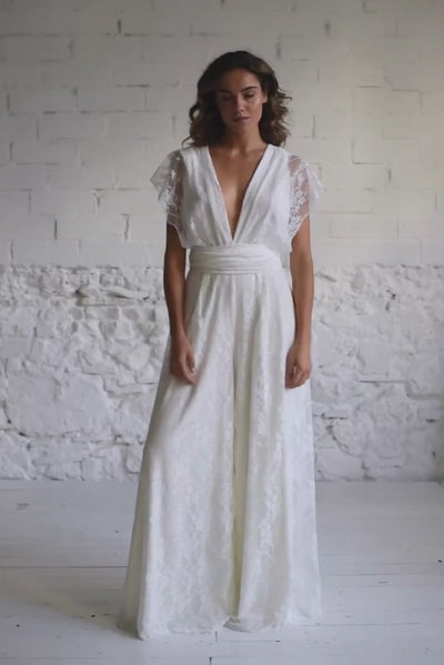 video de modelo andando a cámara con mono de encaje blanco