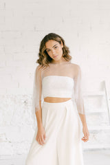 Modelo  vestida de novia para boda civil combinando un tube top y pantalón minimalista con una capa mágica de tul