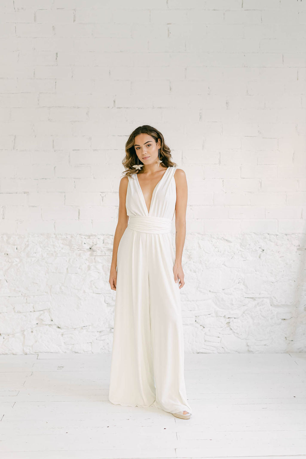 Modelo con un vestido pantalón de novia en blanco. El pantalón es estilo palazzo.