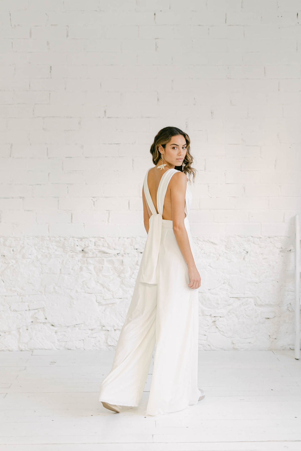 Novia con un vestido pantalón de novia civil. Lleva la espalda al aire.