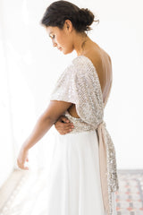 Modelo luciendo la espalda del top de lentejuelas atado en la parte trasera del vestido de novia