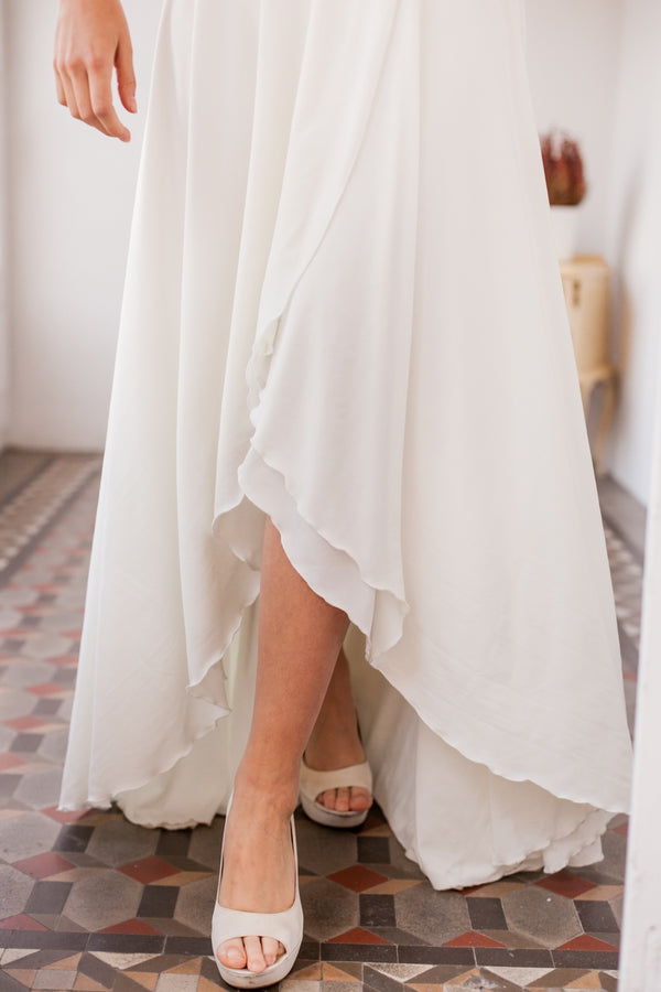 Imagen cercana de la parte inferior del vestido de novia, donde se luce el detalle de la asimetria