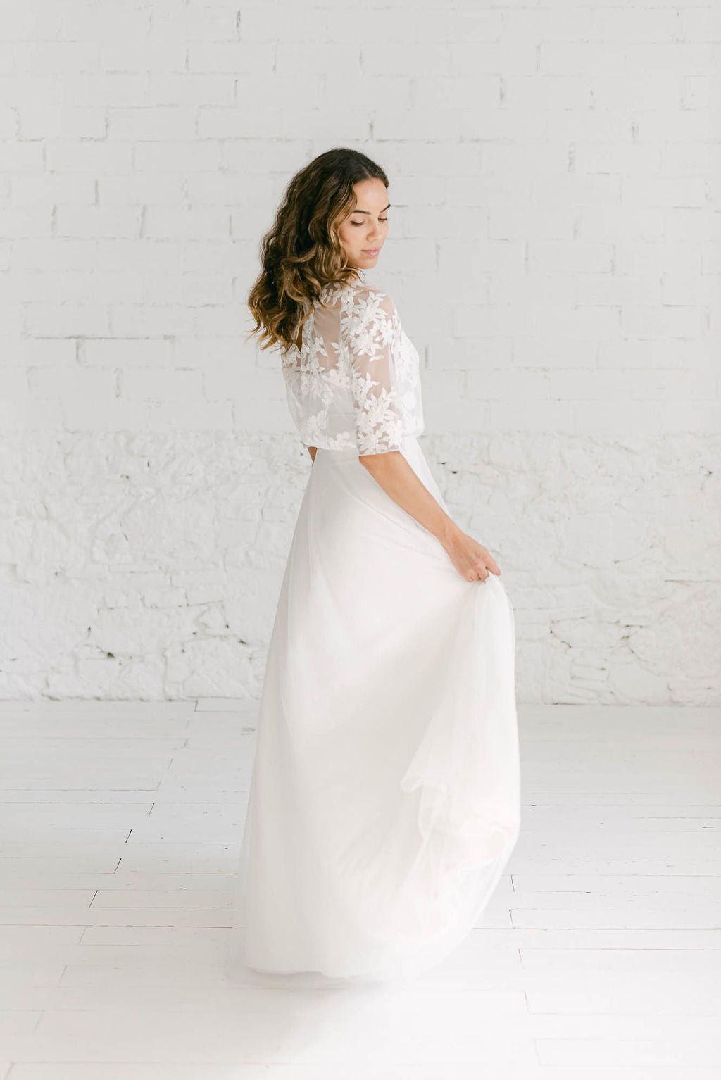 Modelo de espaldas a la cámara con vestido de novia de tul y espalda abierta.