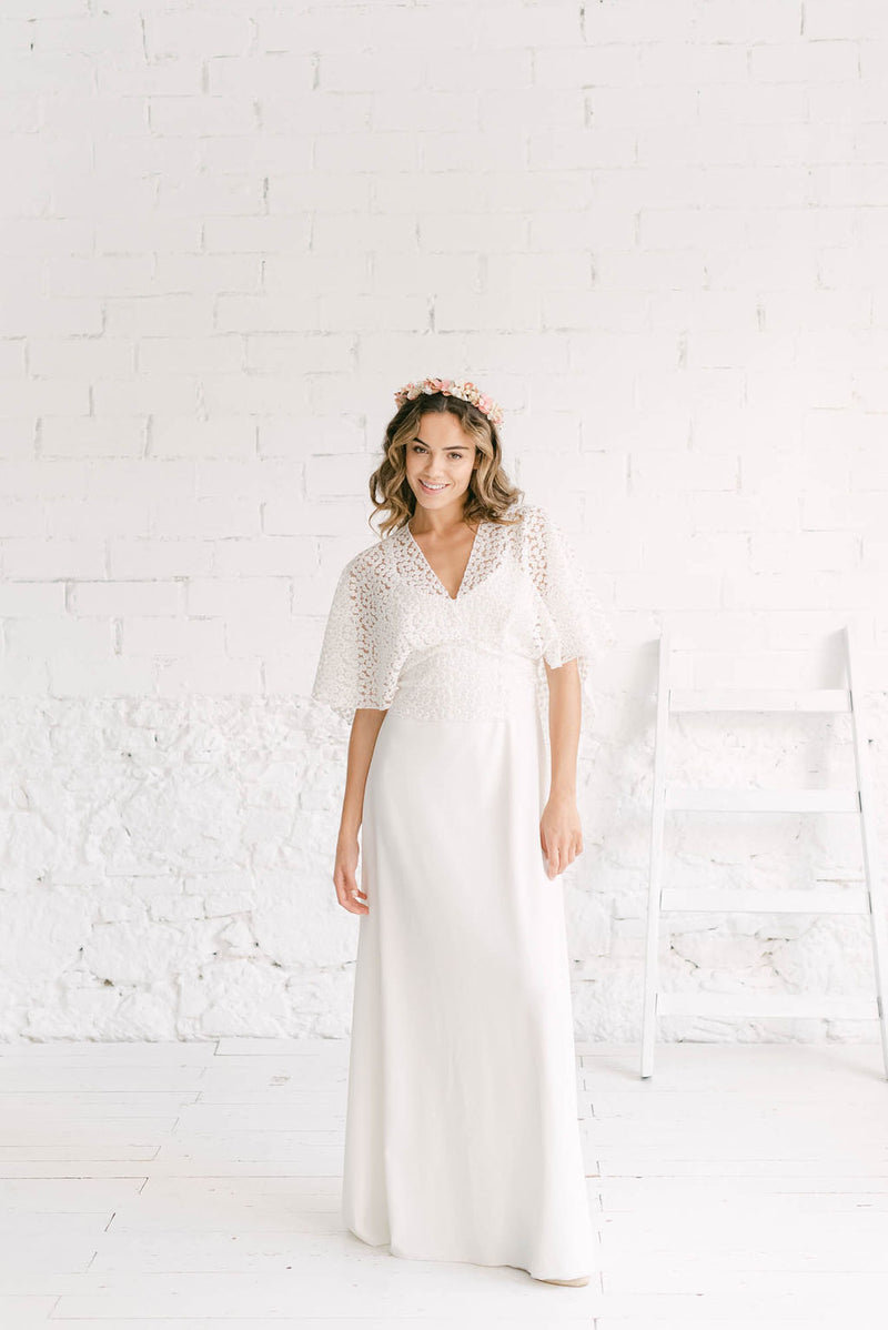 modelo vestida con traje de novia largo con top lilly de escote en V y capa corta.